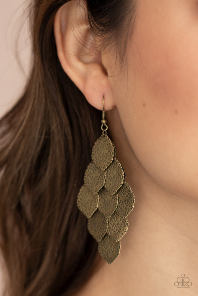 Hammered in antiqued details, leafy brass frames cascade from the ear, creating a rustic lure. Earring attaches to a standard fishhook fitting.  Sold as one pair of earrings.