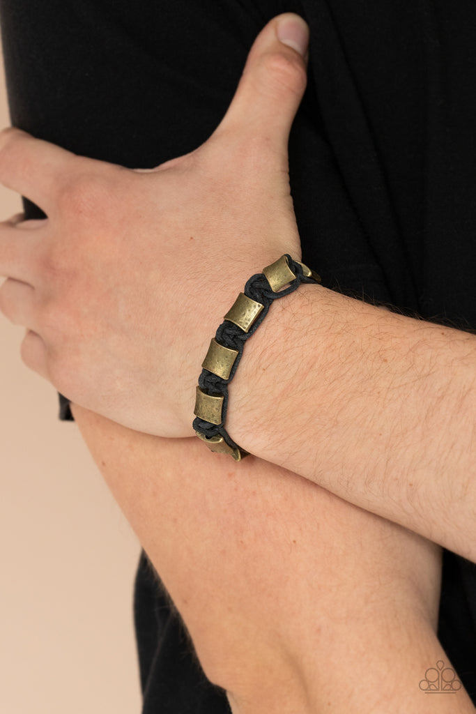 Featuring a hammered finish, a collection of rustic brass accents are knotted in place with black cording around the wrist for a rugged look. Features a button loop closure.  Sold as one individual bracelet.