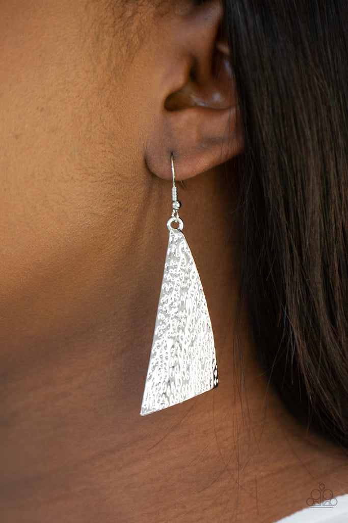 Delicately hammered in blinding shimmer, an asymmetrical silver frame delicately curls into an edgy statement piece. Earring attaches to a standard fishhook fitting.  Sold as one pair of earrings.