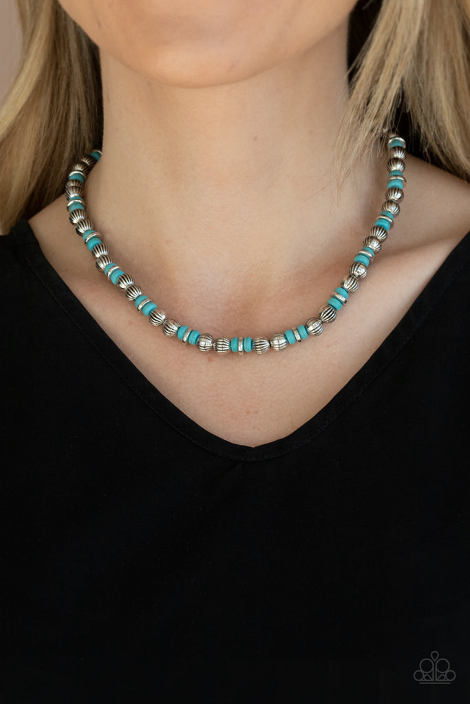A rustic collection of silver discs, ornate silver beads, and refreshing turquoise stones are threaded along an invisible wire below the collar for a seasonal look. Features an adjustable clasp closure.  Sold as one individual necklace. Includes one pair of matching earrings.