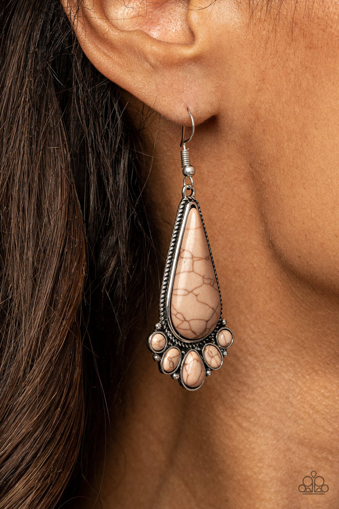 A dainty collection of round, oval, and teardrop brown stones fan out from the bottom of an oversized teardrop brown stone frame for a simple seasonal flair. Earring attaches to a standard fishhook fitting.  Sold as one pair of earrings.