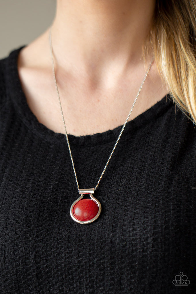 Encased in an artisan inspired silver fitting, a fiery red stone pendant glides along a silver chain for a colorfully seasonal look. Features an adjustable clasp closure.  Sold as one individual necklace. Includes one pair of matching earrings.