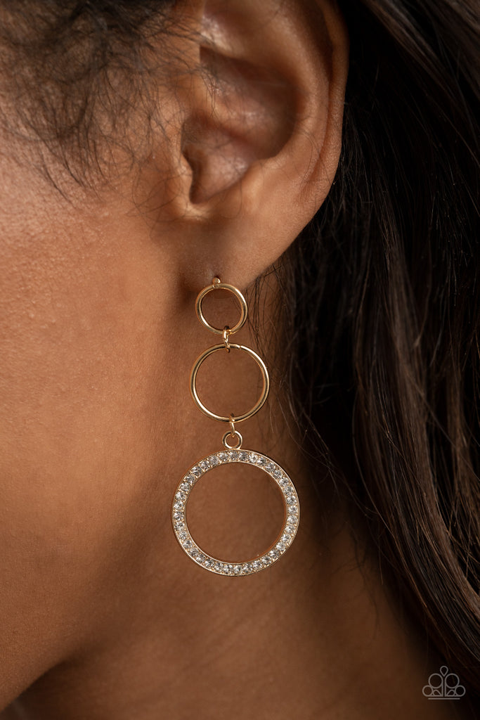 Two dainty gold rings give way to a white rhinestone encrusted gold hoop, adding a timeless twist to the dazzling display. Earring attaches to a standard post fitting.  Sold as one pair of post earrings.