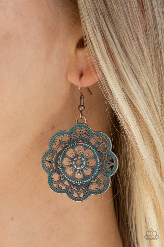 Featuring a rustic patina finish, a decorative mandala-like copper frame swings from the ear for a whimsical look. Earring attaches to a standard fishhook fitting.  Sold as one pair of earrings.
