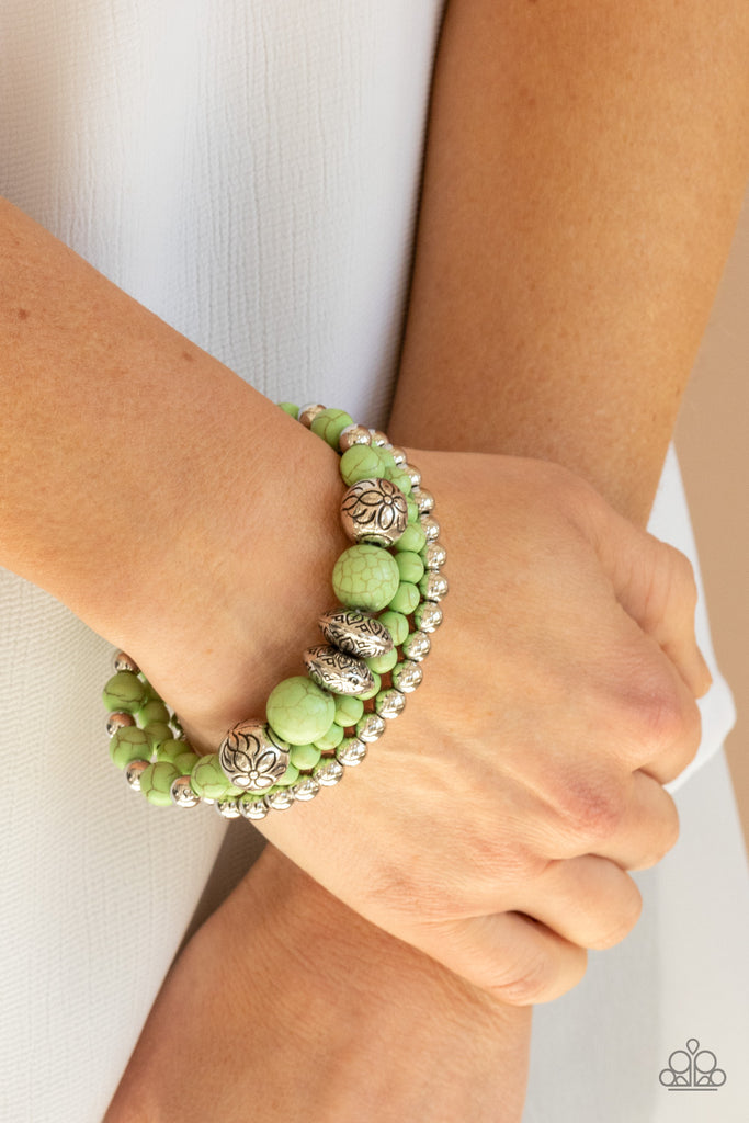 A whimsically mismatched collection of green stone beads, plain silver beads, and antiqued floral accents are threaded along stretchy bands around the wrist, creating colorful layers.  Sold as one set of three bracelets.