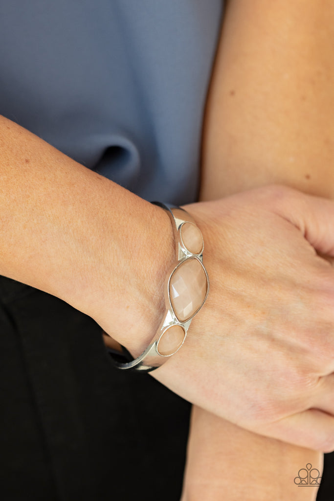 Featuring faceted surfaces, an asymmetrical collection of cloudy Desert Mist faux stone beads are pressed into the front of a silver cuff, creating a mystical centerpiece around the wrist.  Sold as one individual bracelet.