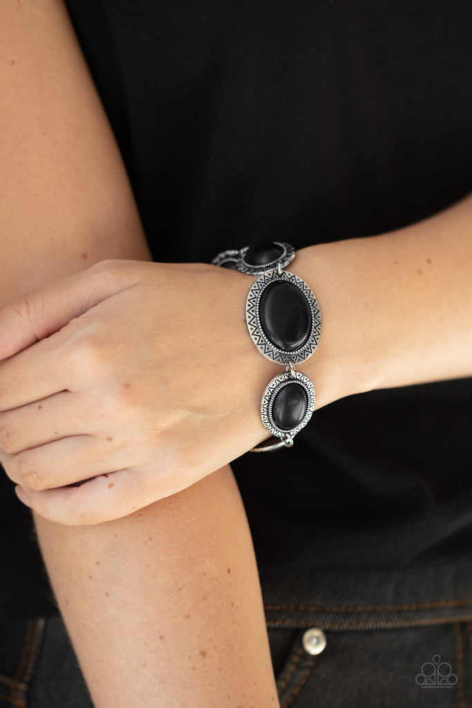 Stamped in dotted sunburst patterns, black oval stone encrusted silver frames delicately link around the wrist for a colorful southwestern flair. Features an adjustable clasp closure.  Sold as one individual bracelet.  