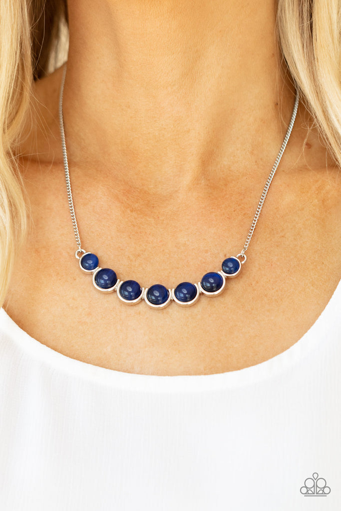 A row of glowing blue cat's eye stones are held in place by a series of interconnected shiny silver frames, creating a whimsically scalloped pendant below the collar. Features an adjustable clasp closure.  Sold as one individual necklace. Includes one pair of matching earrings.  New Kit