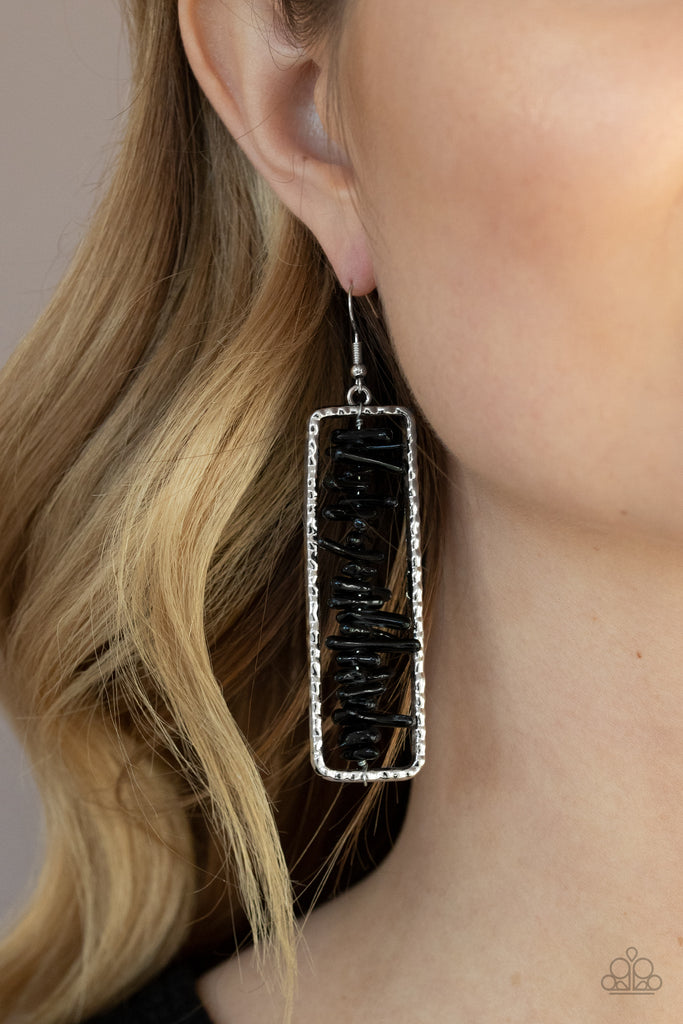 Bits of black rock are threaded along a metal rod inside a hammered silver rectangle, creating an earthy frame. Earring attaches to a standard fishhook fitting.  Sold as one pair of earrings.