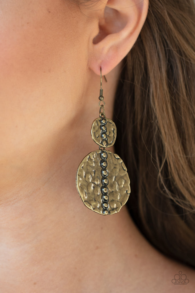 Embossed in tactile textures, a studded pair of asymmetrical brass discs connect into a rustic lure. Earring attaches to a standard fishhook fitting.  Sold as one pair of earrings.