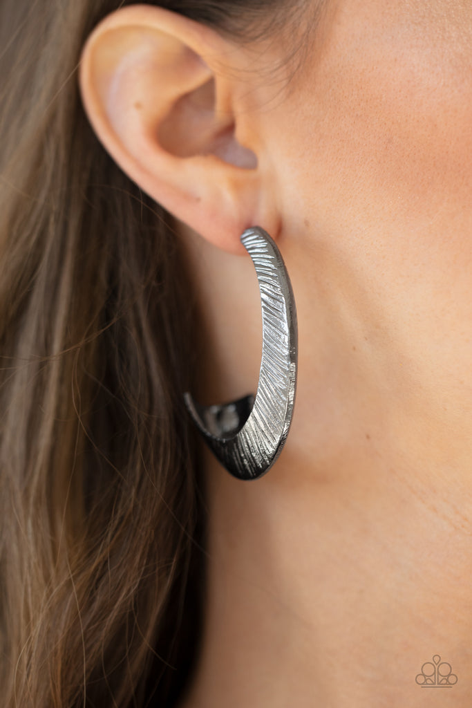 Etched in sporadic linear patterns, two shimmery gunmetal frames join into a hollow hook that flares out into an eye-catching hoop. Earring attaches to a standard post fitting. Hoop measures approximately 1 1/2" in diameter.  Sold as one pair of hoop earrings.