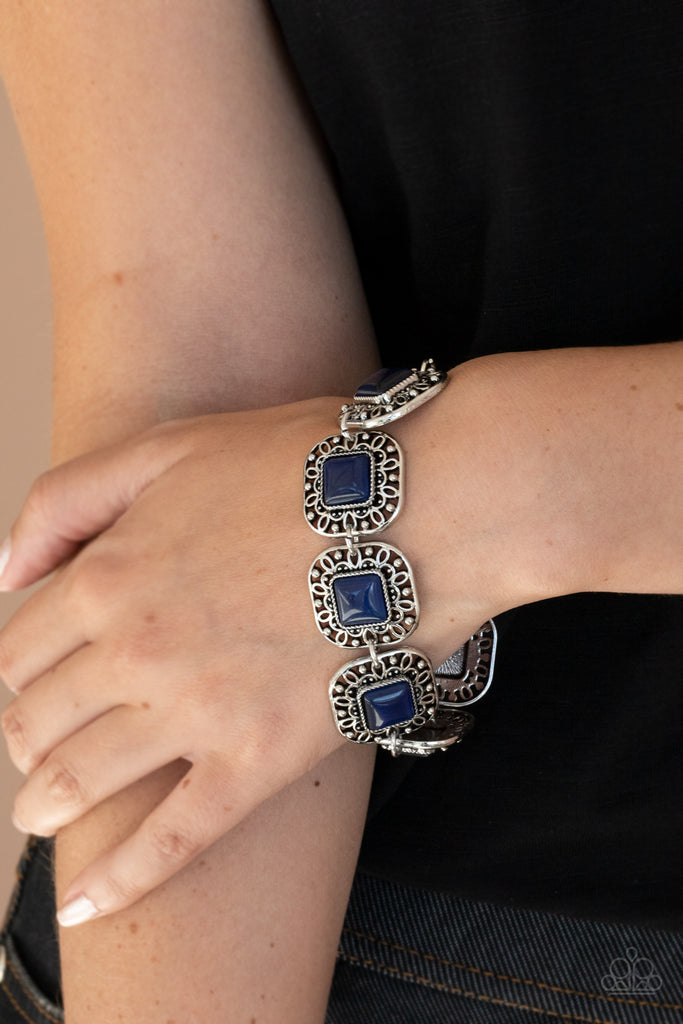 Dotted with blue cat's eye stones, square filigree filled silver frames delicately link around the wrist for a dreamy display. Features an adjustable clasp closure.  Sold as one individual bracelet.  