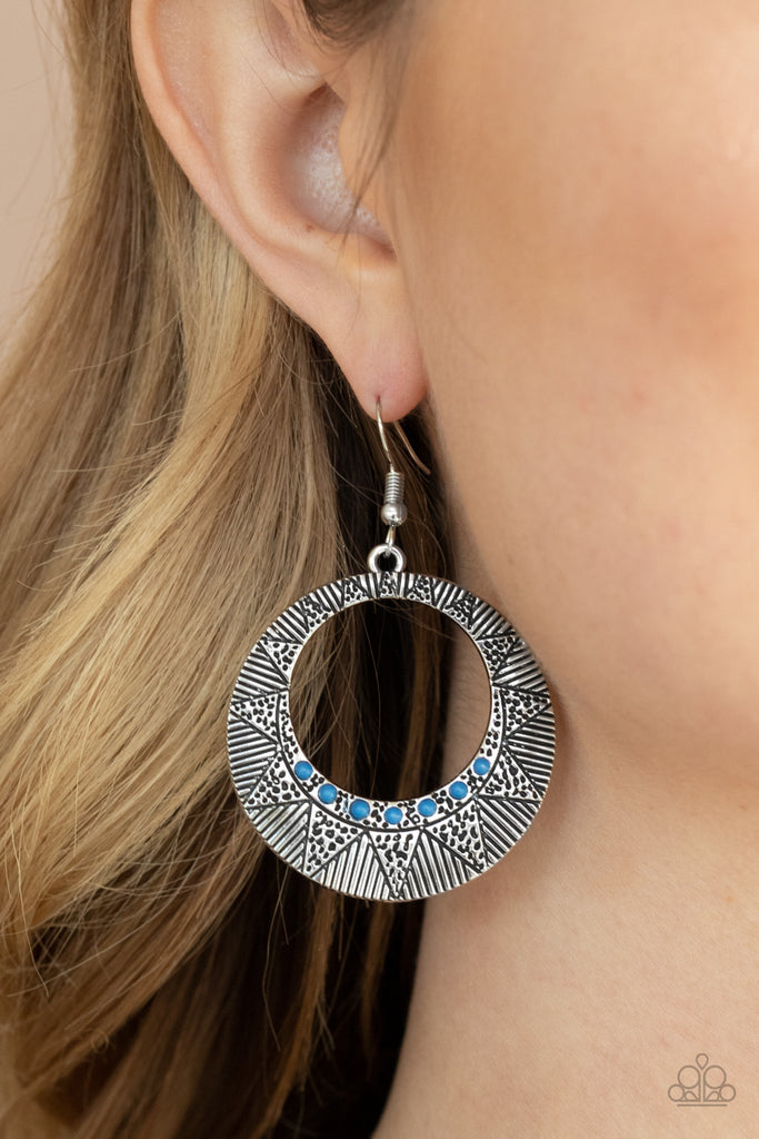 Dotted in a row of dainty blue beads, a radiant sunburst pattern is stamped across a silver hoop for a colorfully seasonal look. Earring attaches to a standard fishhook fitting.  Sold as one pair of earrings.  