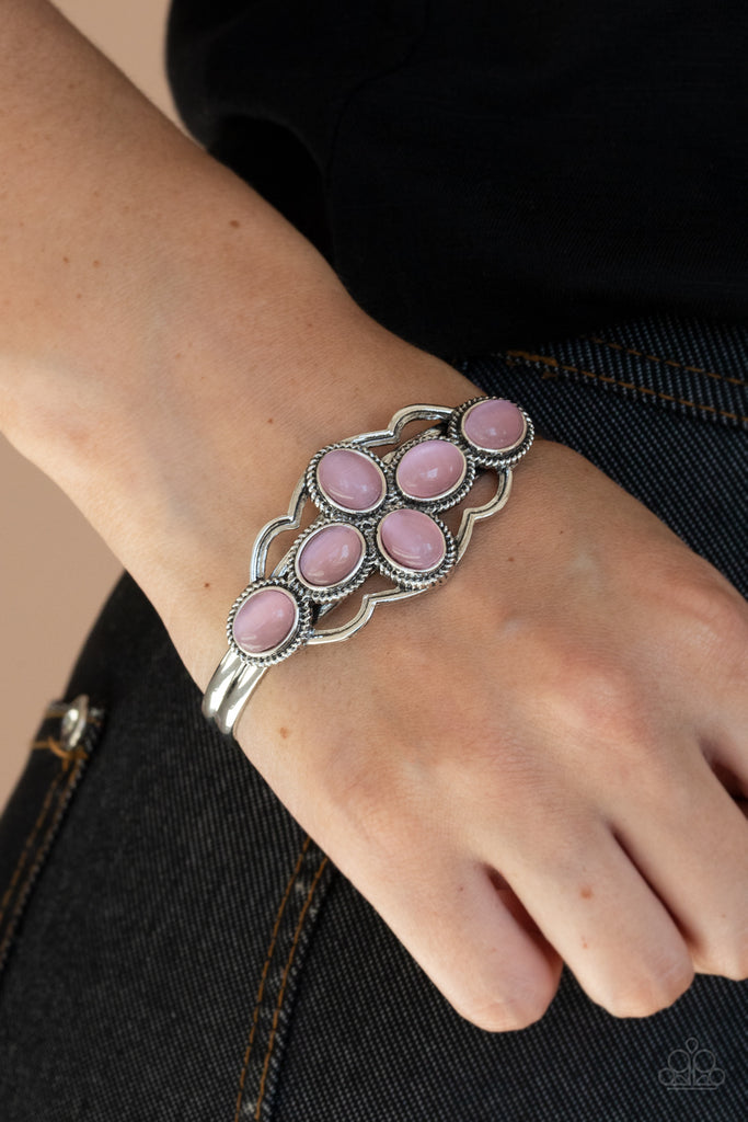 A collection of glowing pink cat's eye stones delicately cluster inside a scalloped silver frame, creating an ethereal centerpiece atop a dainty silver cuff.  Sold as one individual bracelet.
