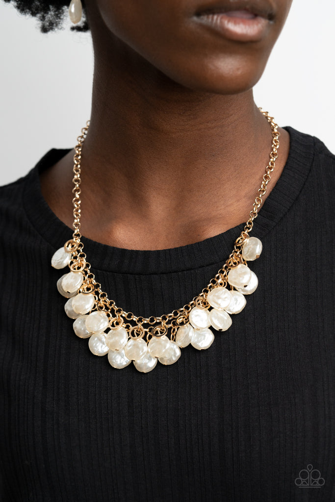 Featuring delicately hammered surfaces, rows of pearly white beads cascade from the bottoms of interlocking gold chains. Dainty gold rings swing from the top of the timelessly tiered display, creating a refined fringe below the collar. Features an adjustable clasp closure.  Sold as one individual necklace. Includes one pair of matching earrings.