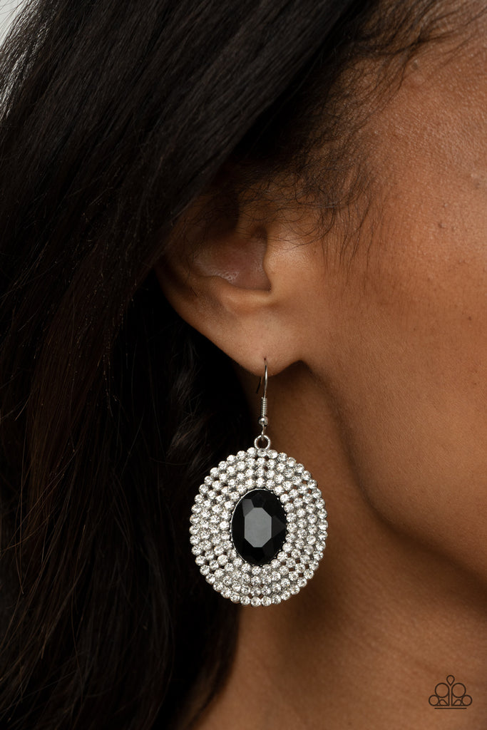 A black oval gem is pressed into the center of ring after ring of glassy white rhinestones, radiating out into a glamorously glittering centerpiece. Earring attaches to a standard fishhook fitting.  Sold as one pair of earrings.
