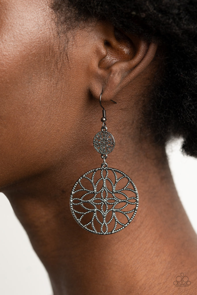 Featuring a stenciled mandala-like pattern, a studded gunmetal frame swings from a dainty matching frame, creating a whimsical lure. Earring attaches to a standard fishhook fitting.  Sold as one pair of earrings.  