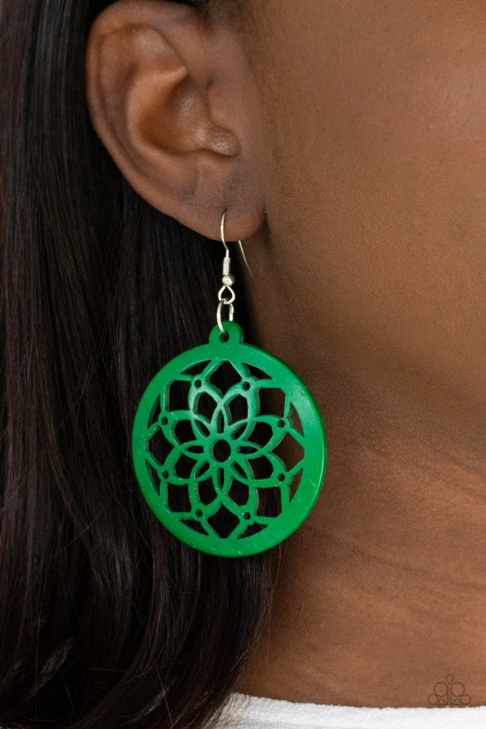 The center of a green wooden frame has been cutout in an airy mandala-like pattern, creating a colorful flower. Earring attaches to a standard fishhook fitting.  Sold as one pair of earrings.