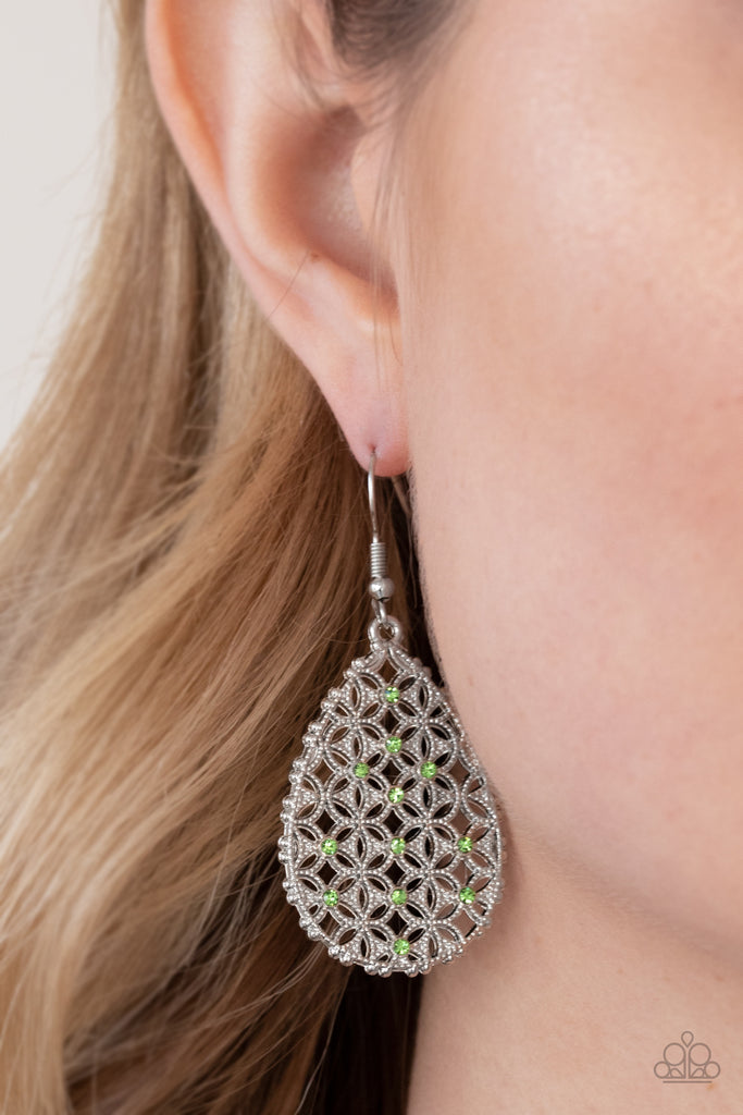 Dainty green rhinestones are encrusted across the front of a silver teardrop frame filled with ornate tactile filigree, creating a whimsical lure. Earring attaches to a standard fishhook fitting  Sold as one pair of earrings.  