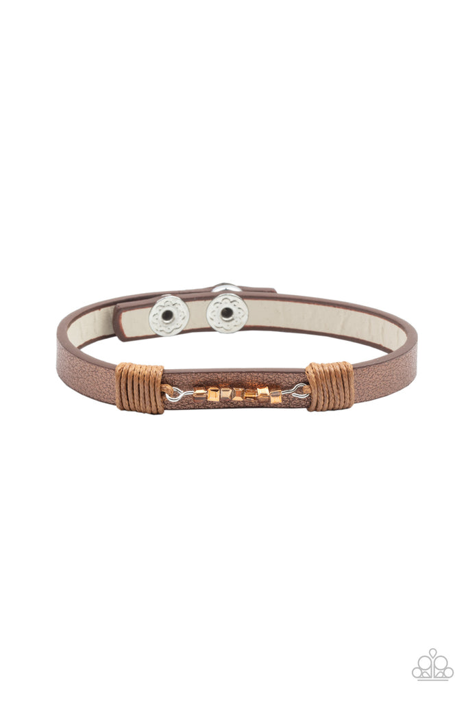 Threaded along a dainty rod, a row of coppery aurum cube beads are knotted in place across the center of a dainty leather band. Features an adjustable snap closure.  Sold as one individual bracelet.