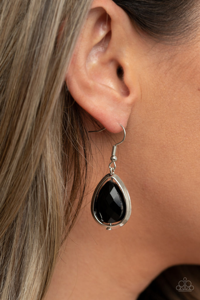 Featuring a reflective metallic back, a glittery black rhinestone gem is threaded along a rod inside a silver teardrop casing, creating a glamorous lure. Earring attaches to a standard fishhook fitting.  Sold as one pair of earrings.