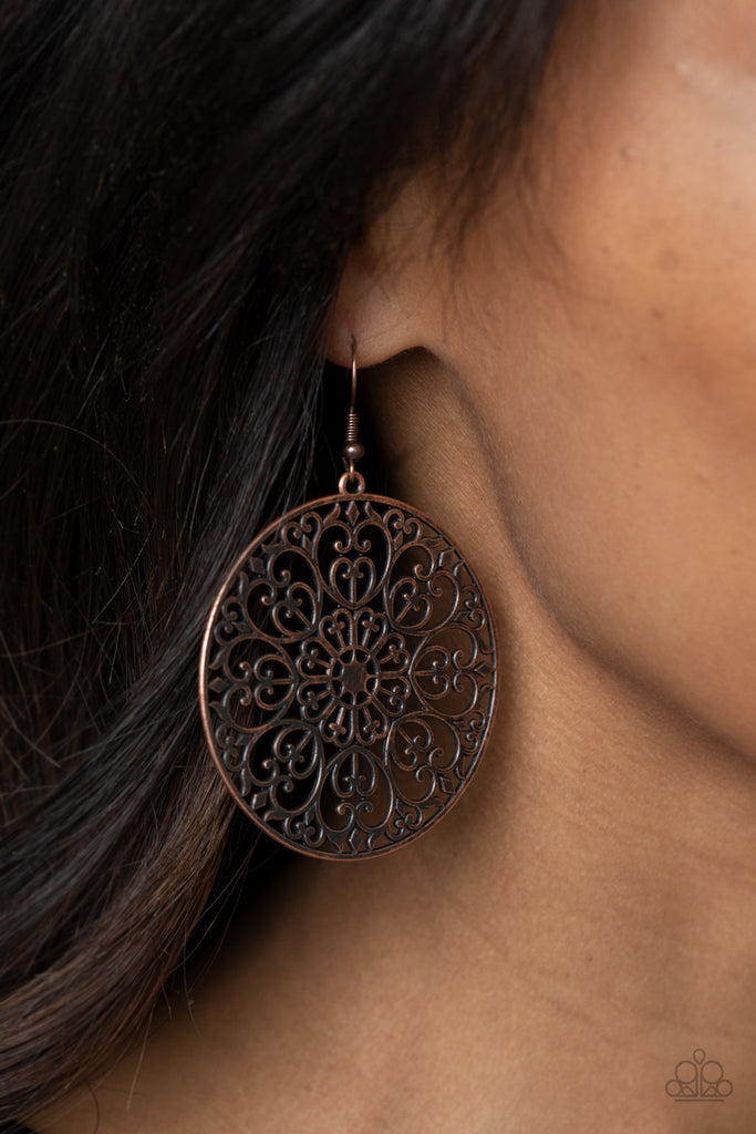 Decorative copper filigree fills the center of a copper hoop, creating a whimsical mandala pattern. Earring attaches to a standard fishhook fitting.  Sold as one pair of earrings.  