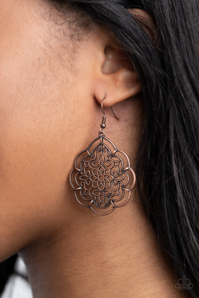 The center of a scalloped copper frame is filled with airy floral filigree, creating a whimsically rustic frame. Earring attaches to a standard fishhook fitting.  Sold as one pair of earrings.