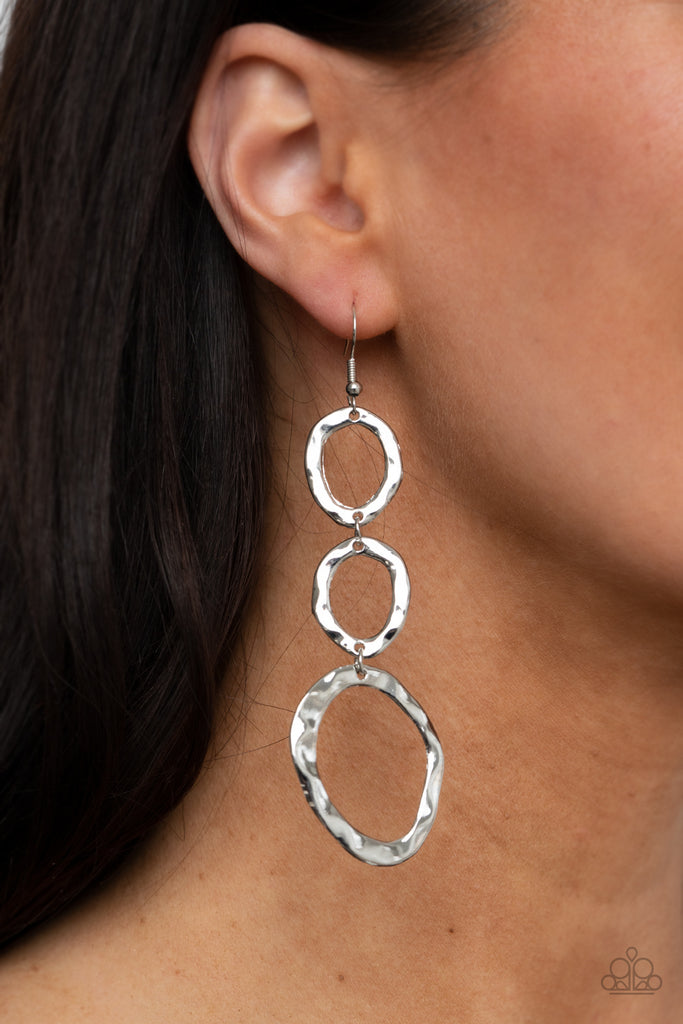 Delicately hammered in rippling shimmer, asymmetrical silver ovals link into an artisan inspired lure. Earring attaches to a standard fishhook fitting.  Sold as one pair of earrings.  
