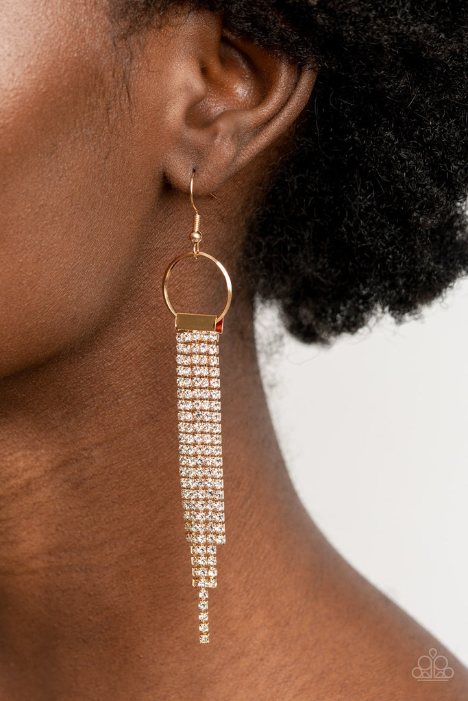 Dainty strands of glittery white rhinestones stream from the bottom of a gold fitting that glides along the bottom of a dainty gold hoop, creating a timelessly tapered fringe. Earring attaches to a standard fishhook fitting.  Sold as one pair of earrings.