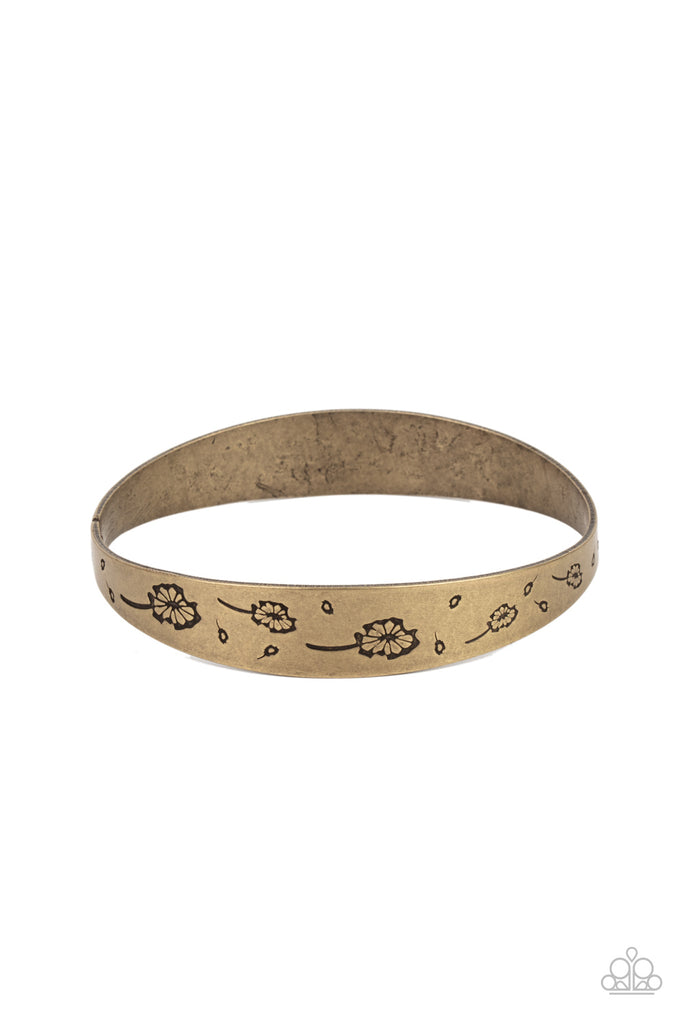 Flowery dandelion-like patterns are stamped across the front of an uneven brass bangle, creating a stackable seasonal display around the wrist.  Sold as one individual bracelet.
