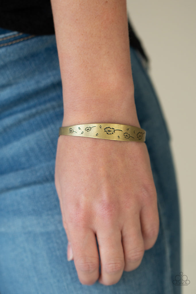 Flowery dandelion-like patterns are stamped across the front of an uneven brass bangle, creating a stackable seasonal display around the wrist.  Sold as one individual bracelet.