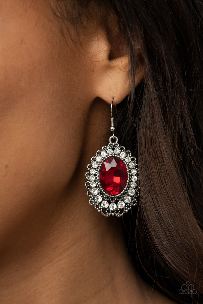 A fiery red gem is pressed into the center of an ornately studded frame bordered in glassy white rhinestones, creating a glamorous statement piece. Earring attaches to a standard fishhook fitting.  Sold as one pair of earrings.