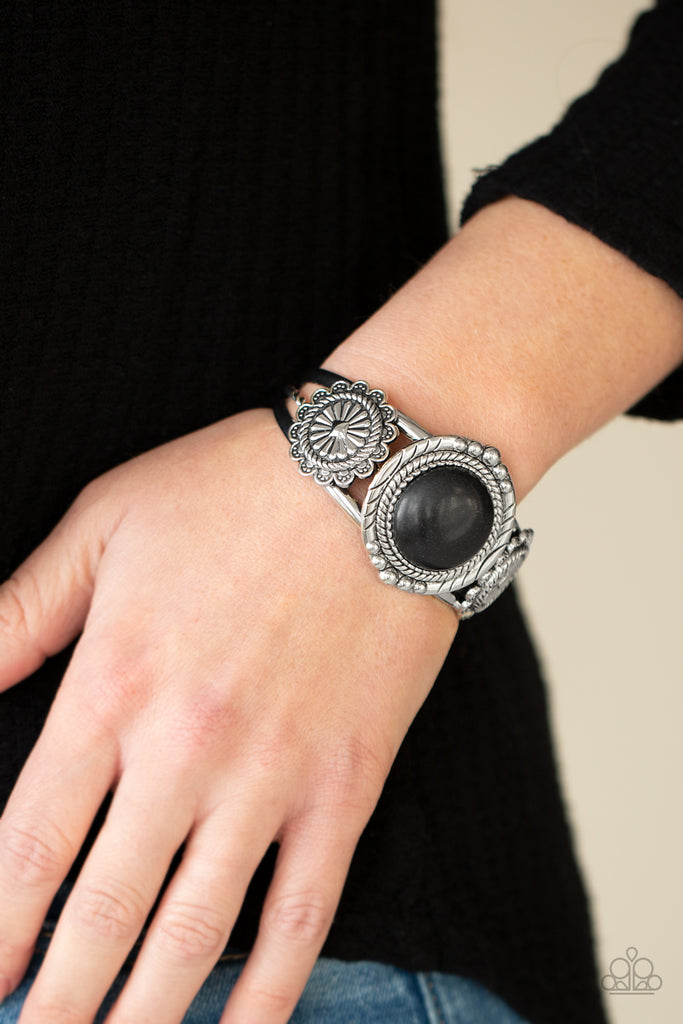 Flanked by two studded silver floral frames, an oversized black stone adorns the center of a layered silver cuff for an authentic southwestern flair.  Sold as one individual bracelet.  