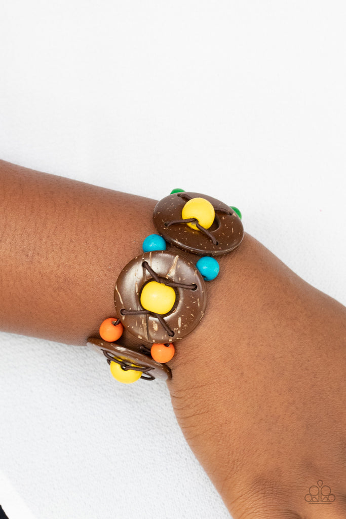 An oversized collection of multicolored beads and distressed brown wooden discs are threaded along stretchy bands that decoratively weave around the wrist for a summery flair.  Sold as one individual bracelet.