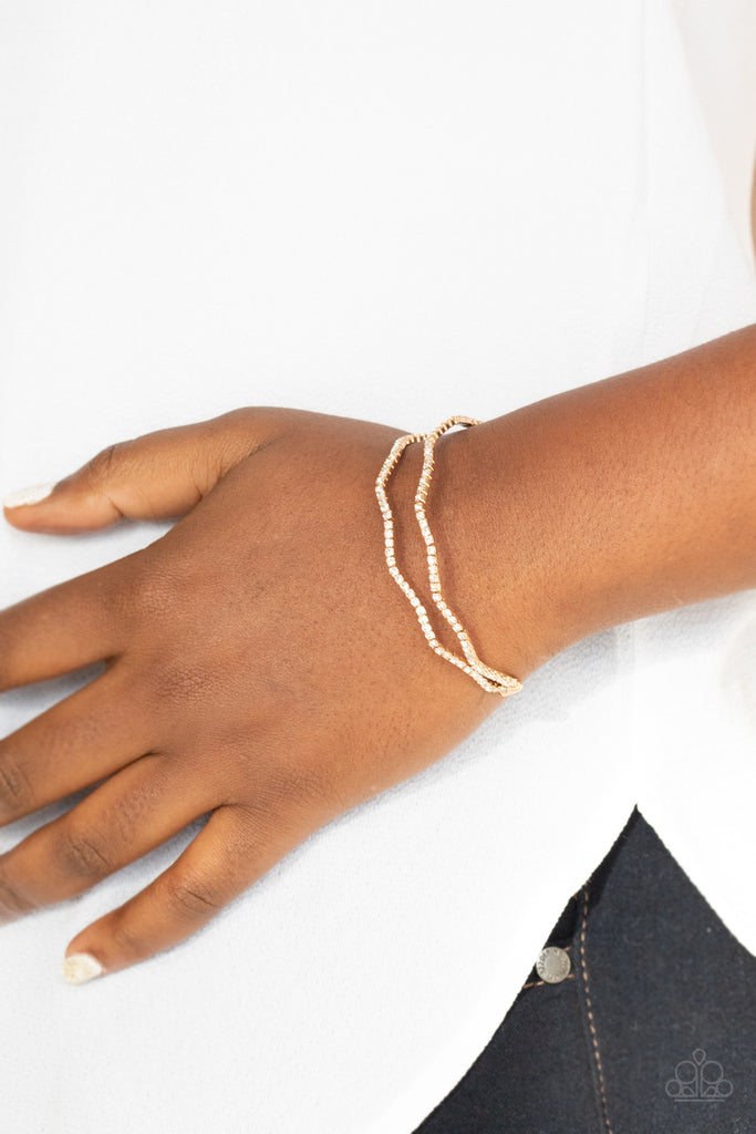 delicate-dazzle-gold  Wavy rows of glittery white rhinestones delicately connect into a dainty gold cuff around the wrist, creating a timeless centerpiece.  Sold as one individual bracelet.