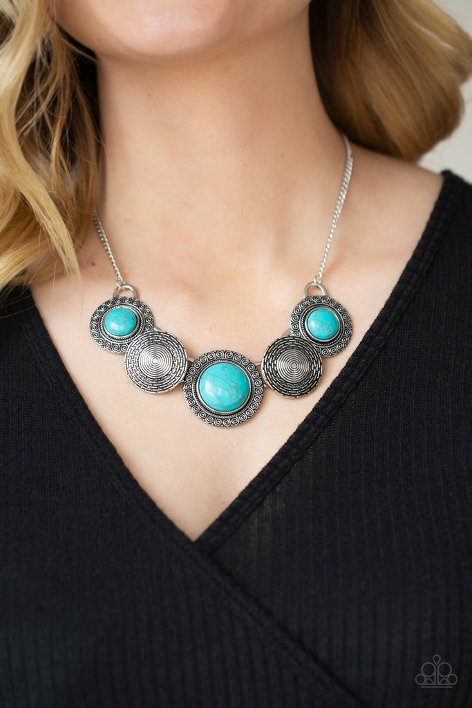 Embossed in swirly patterns, blue turquoise stone frames link with antiqued silver frames radiating with spiral textures below the collar for a seasonal inspired flair. Features an adjustable clasp closure.  Sold as one individual necklace. Includes one pair of matching earrings.  
