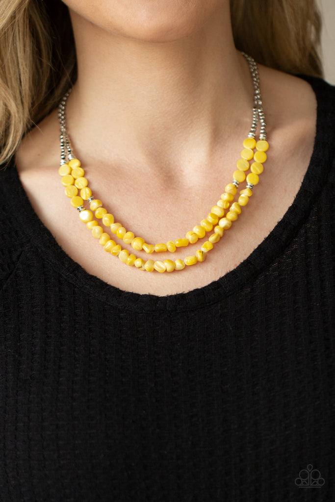 Infused with dainty silver cube and round beaded accents, yellow shell-like beads are threaded along invisible wires below the collar for a summery inspiration. Features an adjustable clasp closure.  Sold as one individual necklace. Includes one pair of matching earrings.  