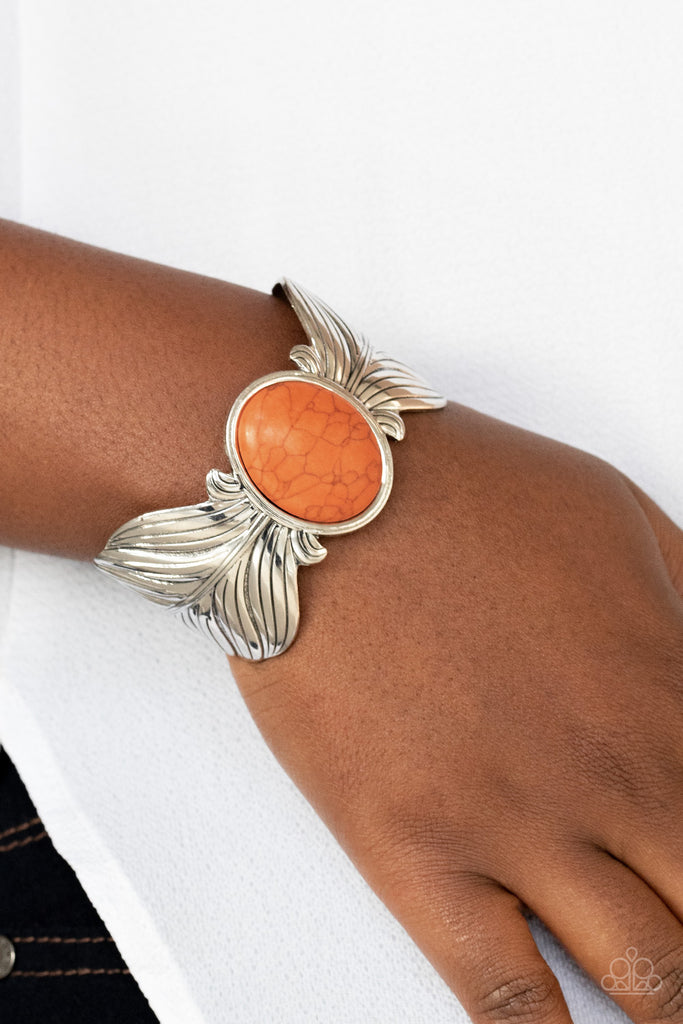 Etched and embossed in lifelike textures, two oversized silver feathers branch out from a refreshing orange stone center, curling into a whimsical cuff around the wrist.  Sold as one individual bracelet.