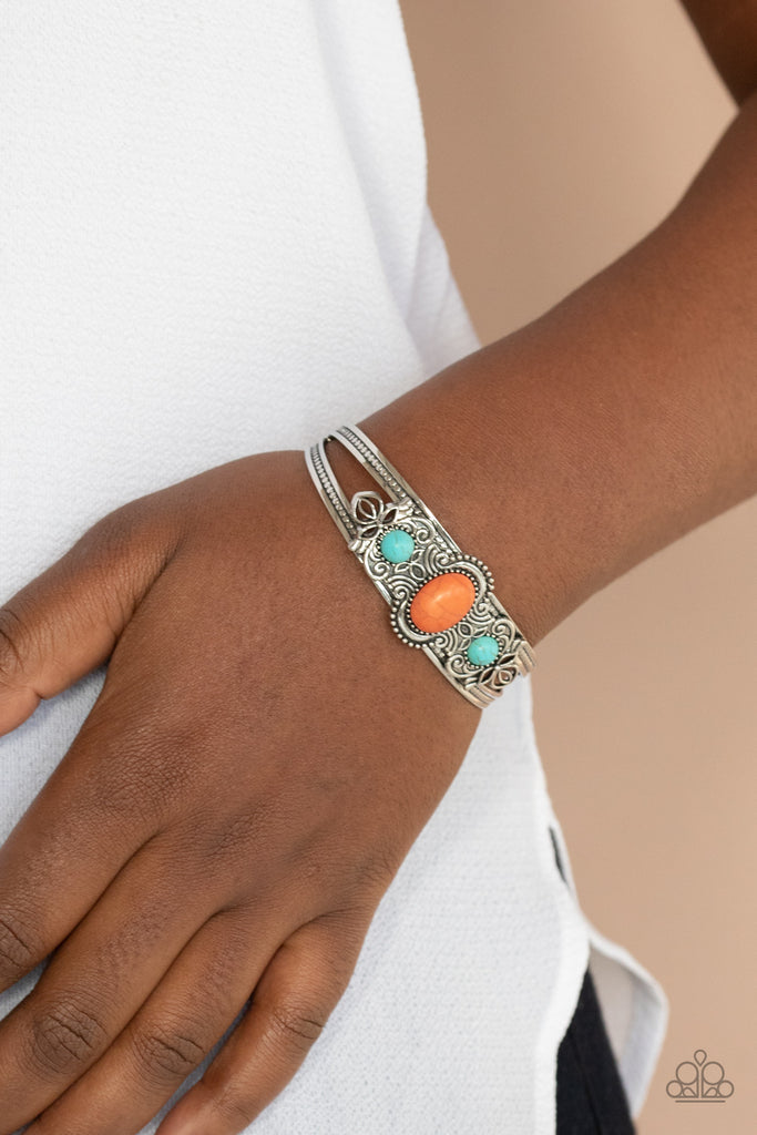 Dotted with a pair of turquoise stone beads, silver floral filigree blooms out from an oval orange stone centerpiece atop a studded silver cuff.  Sold as one individual bracelet.