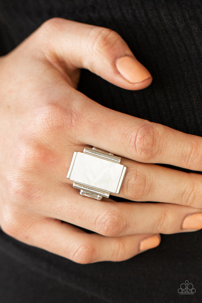 Featuring an iridescent shimmer, a white shell-like rectangle is nestled between silver bar-like fittings atop the finger for a mystical look. Features a stretchy band for a flexible fit.  Sold as one individual ring.  