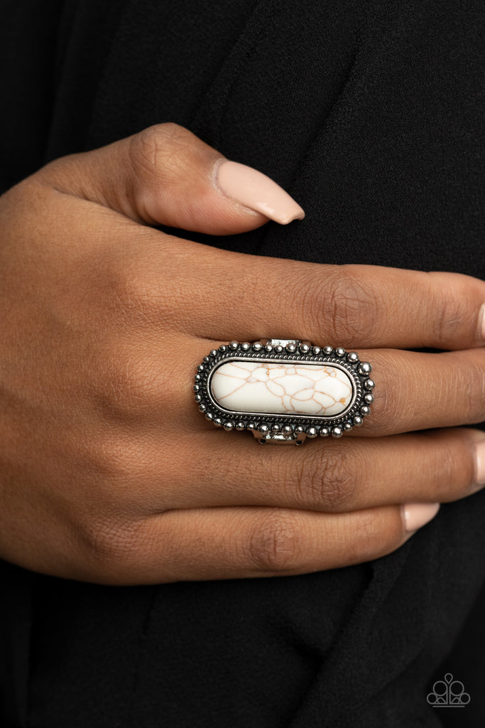 An oblong white stone is nestled inside an oversized studded silver frame, creating a colorfully rustic centerpiece atop the finger. Features a stretchy band for a flexible fit.  Sold as one individual ring.  