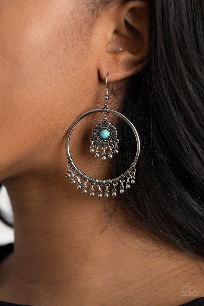 Dotted with a turquoise stone, a dainty sunburst studded frame swings from the top of a shiny silver hoop featuring a silver beaded fringe for a trendy stone look. Earring attaches to a standard fishhook fitting.  Sold as one pair of earrings.