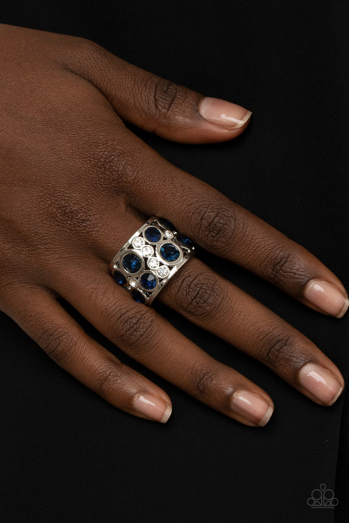 Sporadic sections of dainty white rhinestones and oversized blue rhinestones haphazardly coalesce inside an airy silver frame, creating a dramatically dazzling centerpiece around the finger. Features a stretchy band for a flexible fit.  Sold as one individual ring.
