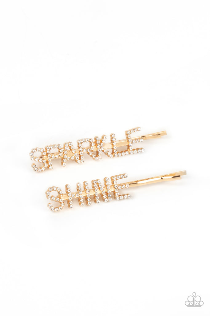 Glassy white rhinestones spell out "Sparkle," and "Shine," across the fronts of two gold bobby pins, creating a sparkly duo.  Sold as one pair of decorative bobby pins.