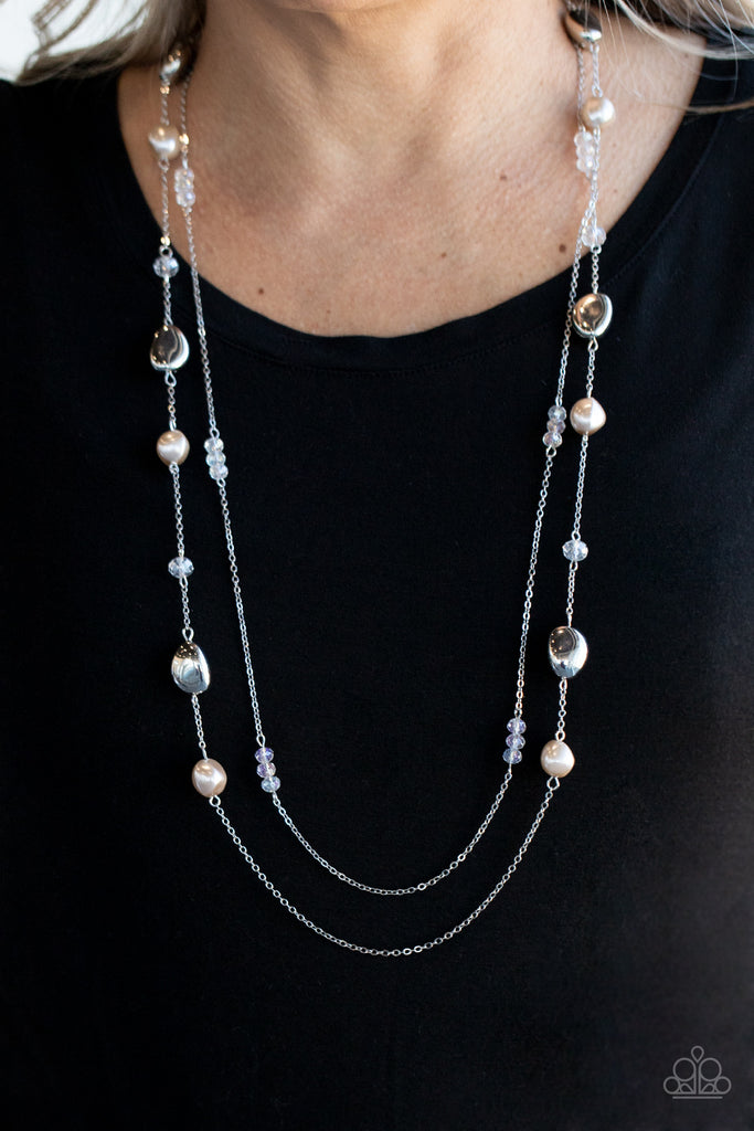 A dainty silver chain adorned in trios of iridescent crystal-like beads layers with a chain dotted with matching crystal-like accents and imperfect silver and pearly brown beads across the chest for a refined flair. Features an adjustable clasp closure.  Sold as one individual necklace. Includes one pair of matching earrings.  