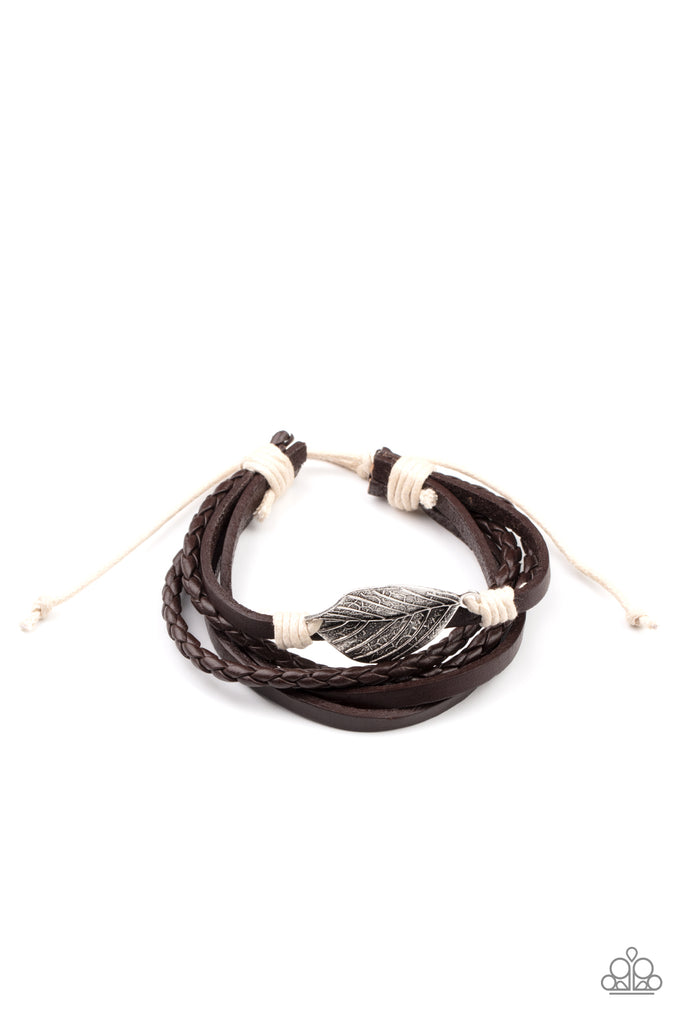 A lifelike silver leaf frame is knotted in place with white cording across the front of a dainty brown leather band. Matching plain and braided leather bands join the centerpiece, creating earthy layers around the wrist. Features an adjustable sliding knot closure.  Sold as one individual bracelet.