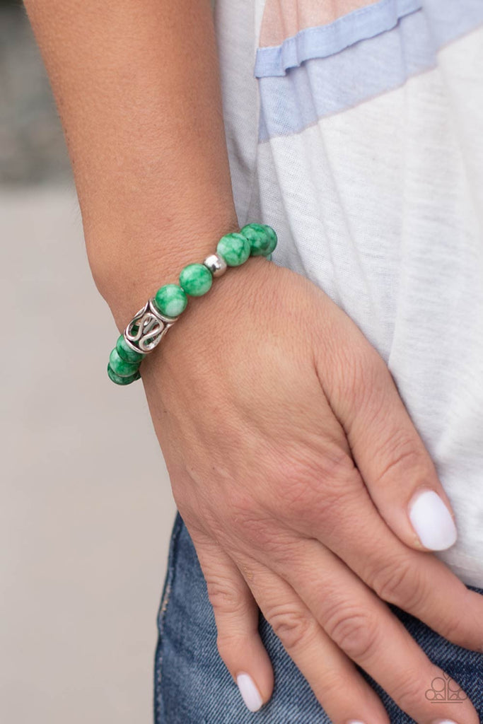 Infused with an ornate silver centerpiece, an earthy collection of silver and jade beads are threaded along a stretchy band around the wrist for a seasonal flair.  Sold as one individual bracelet.