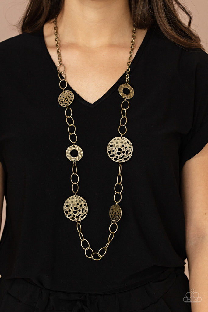 Featuring rustic finishes, hammered brass hoops and holey brass discs link with sections of oversized brass links across the chest for an artisan inspired look. Features an adjustable clasp closure.  Sold as one individual necklace. Includes one pair of matching earrings.  