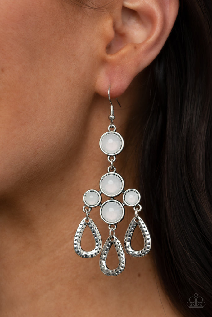 A cluster of bubbly opalescent beaded frames give way to hammered silver teardrops, creating a mystical fringe. Earring attaches to a standard fishhook fitting.  Sold as one pair of earrings.