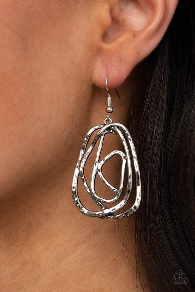 Featuring a hammered finish, a rustic silver wire delicately wraps into an asymmetrical frame for a dizzying artisan-inspired look. Earring attaches to a standard fishhook fitting.  Sold as one pair of earrings.
